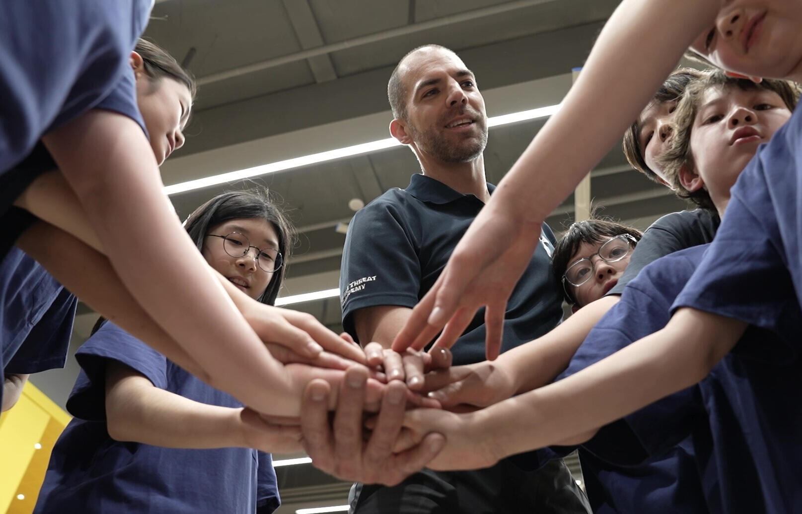 A volunteer enthusiastically greets an expat visitor at a Korean cultural festival information booth, promoting local events and community engagement.